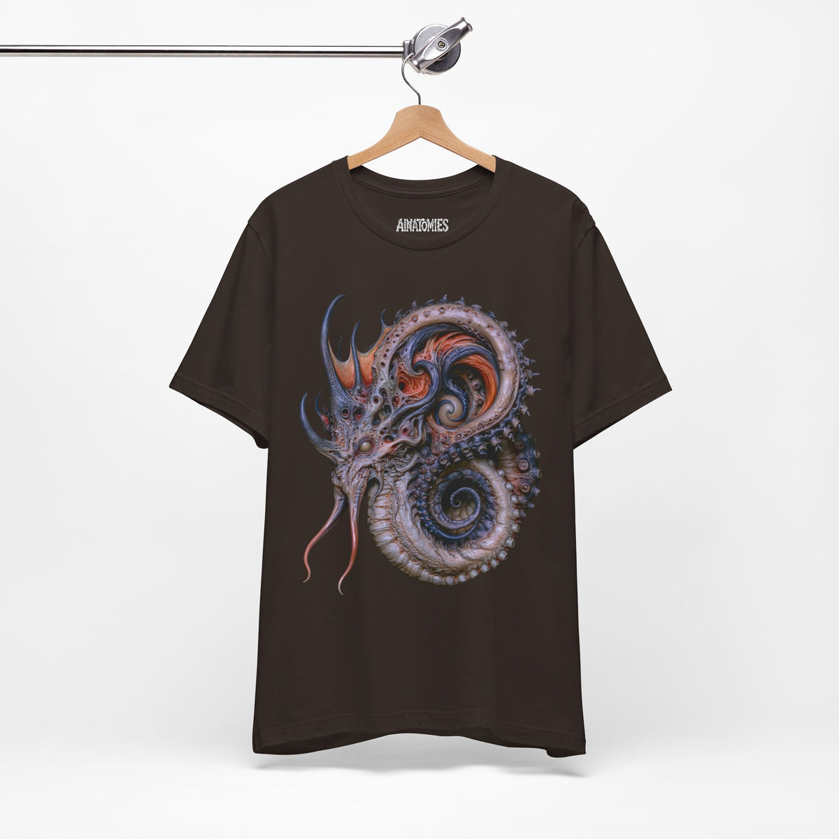 Hanging front view of The Shape of a Rumor T-Shirt in Brown, featuring a coiled sea serpent in violet, orange and blue.